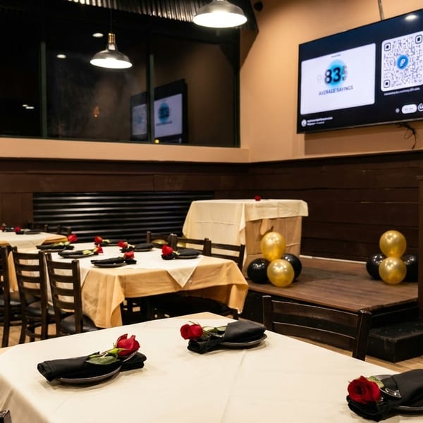 Restaurant dining room with tables set with white and tan tablecloths, black napkins, and red roses.